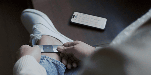 Person using KardiaMobile 6L handheld EKG device to record an EKG on their phone